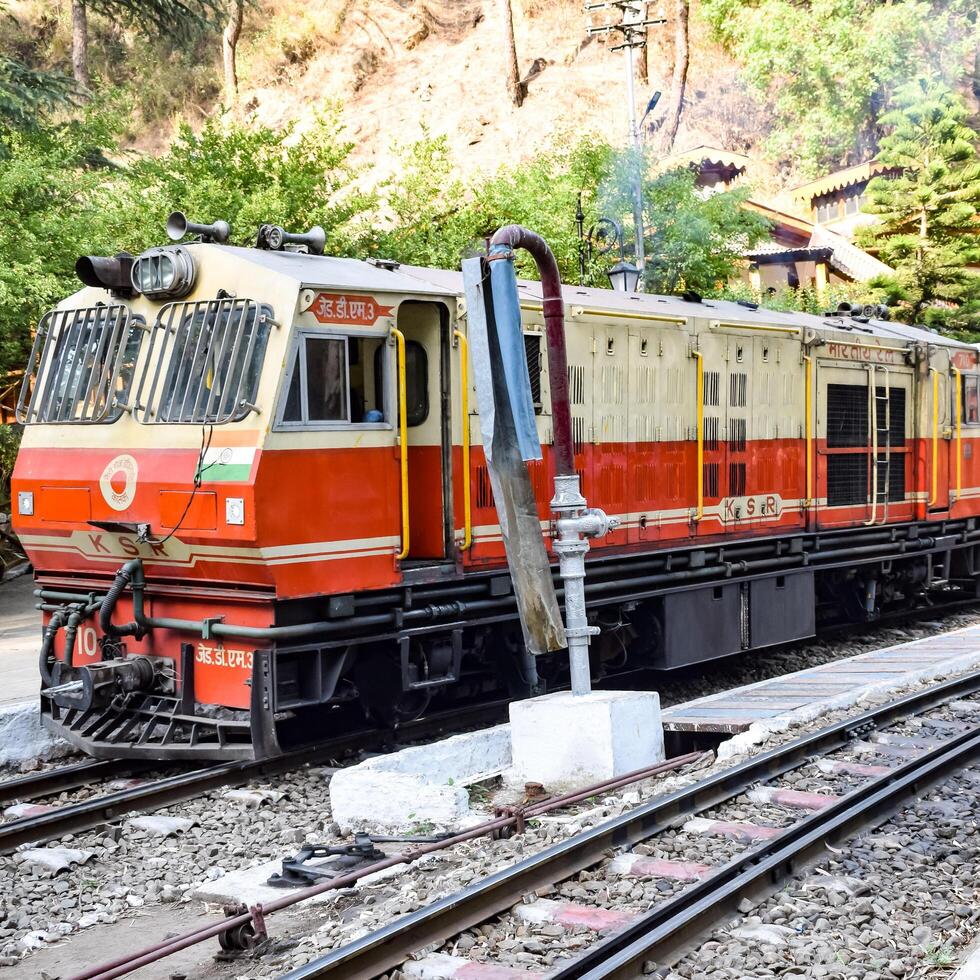 Shimla, Himachal Pradesh, India - August 14, 2023 - Toy train Kalka-Shimla route, moving on railway to the hill, Toy train from Kalka to Shimla in India among green natural forest photo