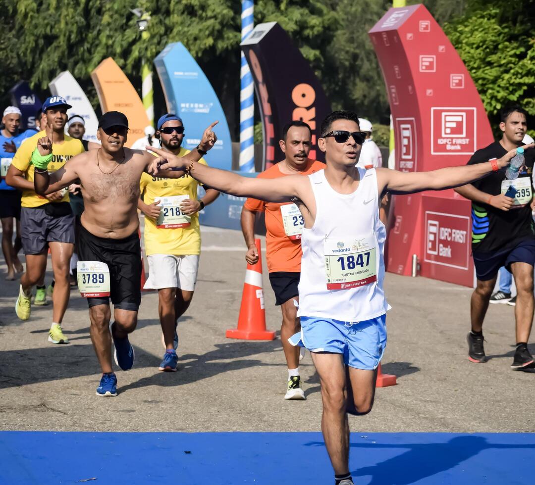 New Delhi, India - October 15 2023 - Vedanta Delhi Half Marathon race after covid in which marathon participants about to cross the finish line, Delhi Half Marathon 2023 photo