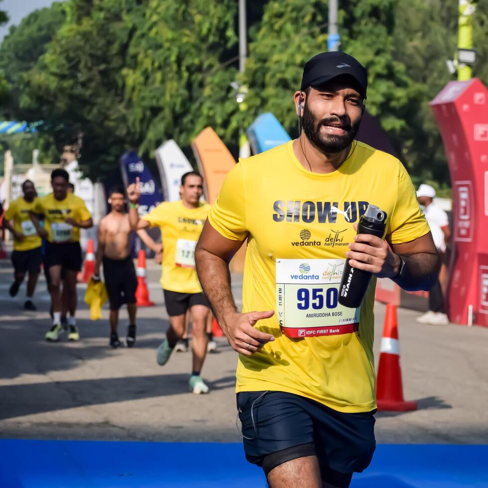 New Delhi, India - October 15 2023 - Vedanta Delhi Half Marathon race after covid in which marathon participants about to cross the finish line, Delhi Half Marathon 2023 photo