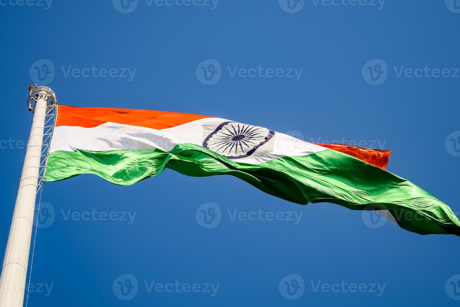India flag flying high at Connaught Place with pride in blue sky, India flag fluttering, Indian Flag on Independence Day and Republic Day of India, tilt up shot, Waving Indian flag, Har Ghar Tiranga photo