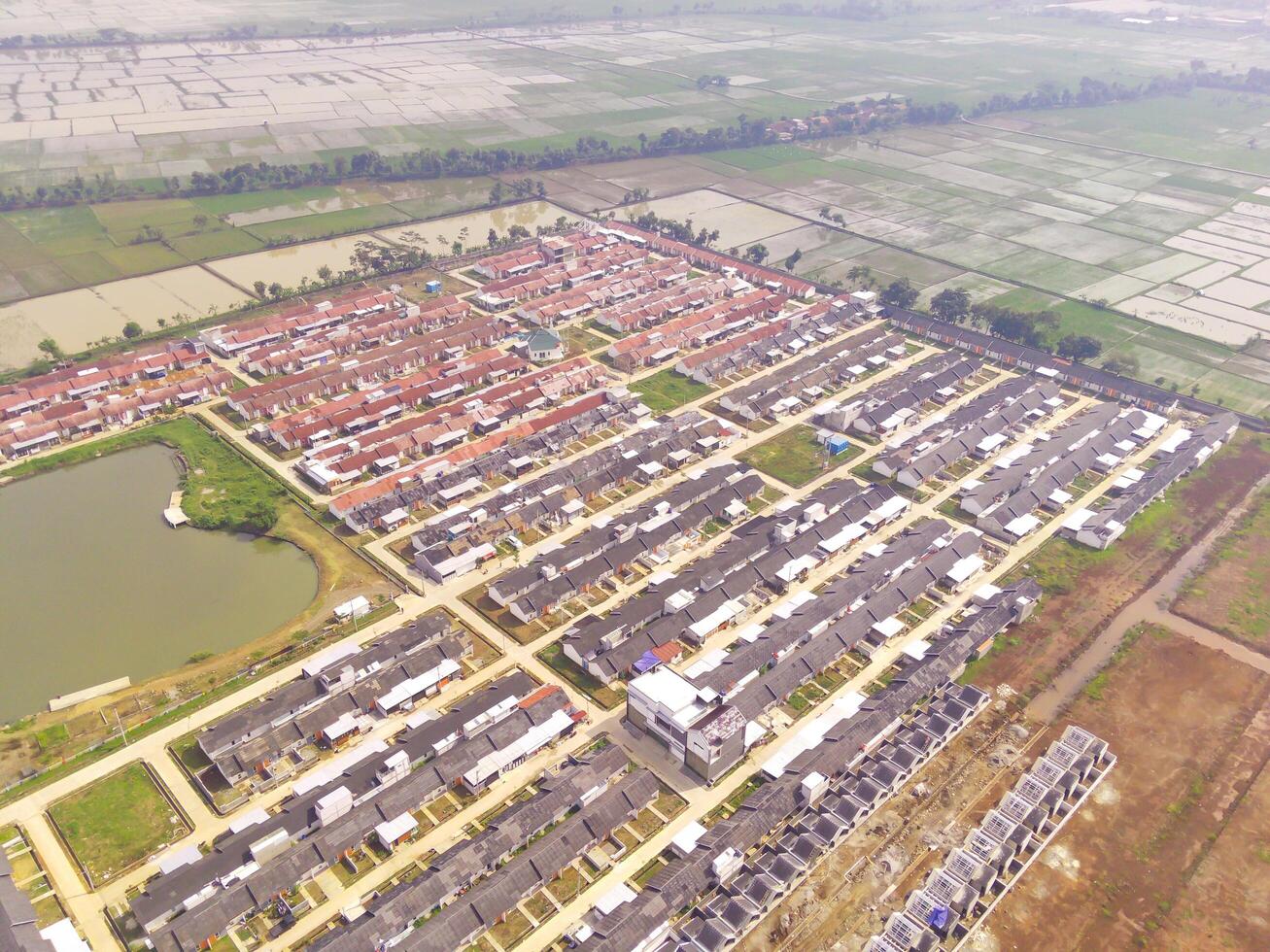 Row of houses in Bandung City from drone. Aerial drone view of public housing on the edge of the city. View from above, Housing Development. Above. Social issues. Shot from drone flying 100 meters photo