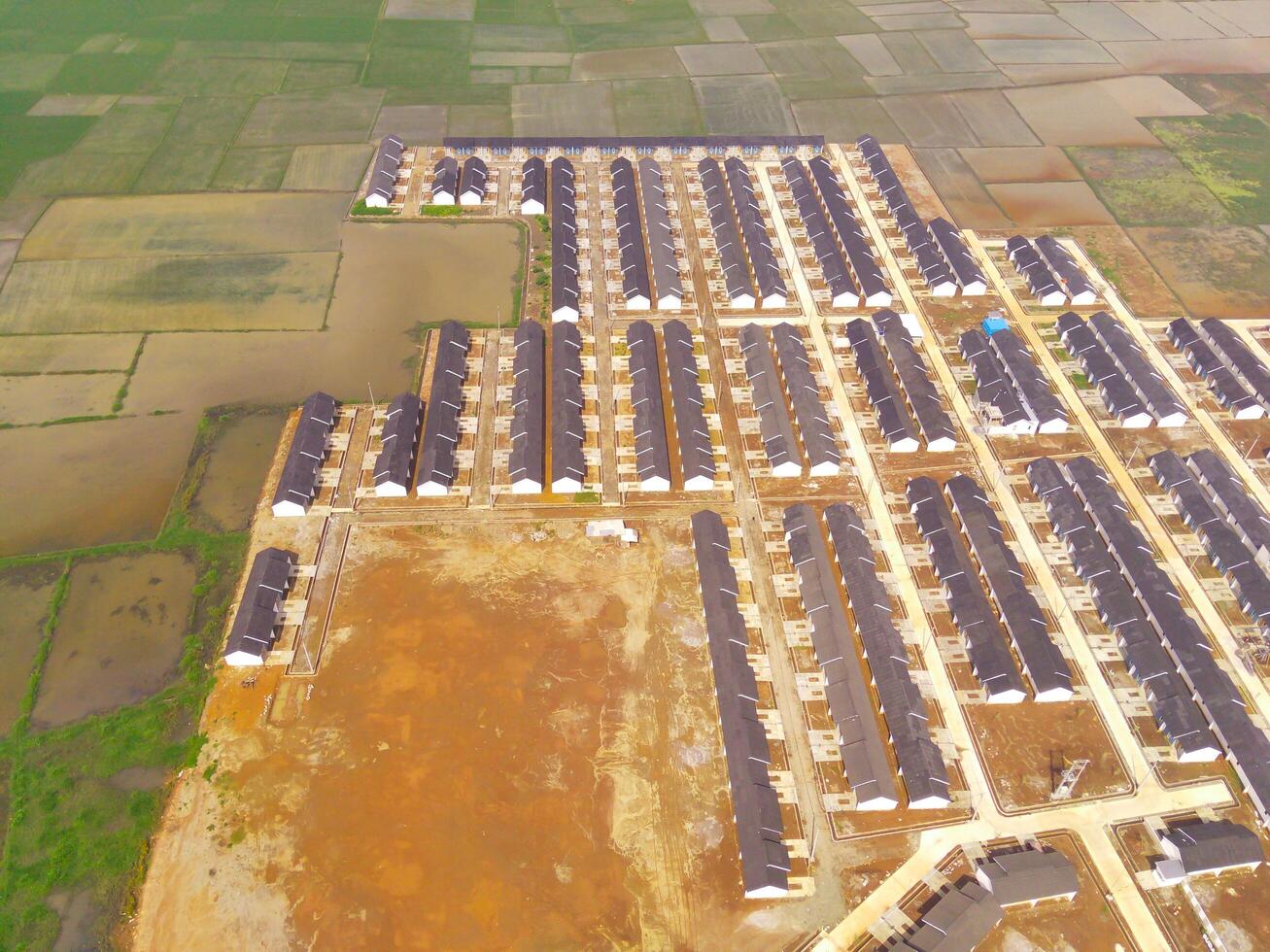 Row of houses in Bandung City from drone. Aerial drone view of public housing on the edge of the city. View from above, Housing Development. Above. Social issues. Shot from drone flying 100 meters photo