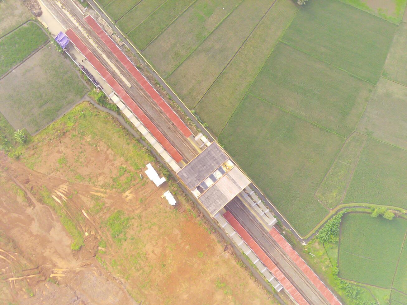 Foggy view of the Railway station. Aerial view of train track and station in Rancaekek, Bandung - Indonesia. Natural conditions. Above. Public transportation. Shot in drone flying 100 meters photo