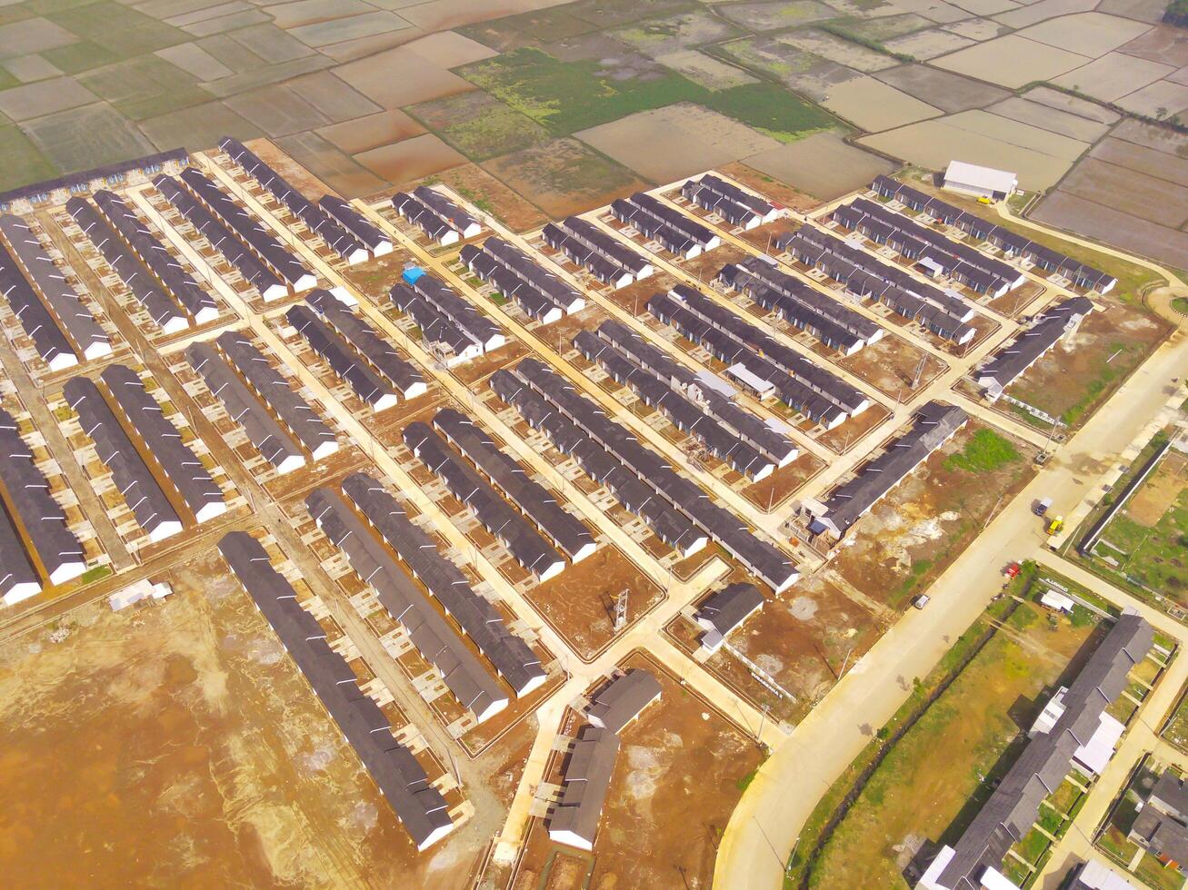 Row of houses in Bandung City from drone. Aerial drone view of public housing on the edge of the city. View from above, Housing Development. Above. Social issues. Shot from drone flying 100 meters photo