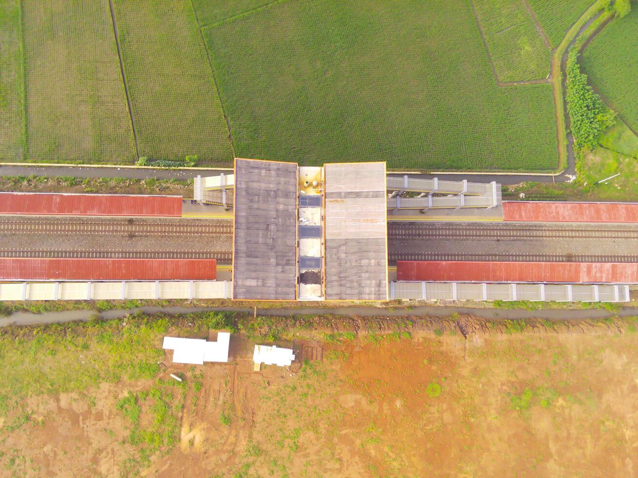 Foggy view of the Railway station. Aerial view of train track and station in Rancaekek, Bandung - Indonesia. Natural conditions. Above. Public transportation. Shot in drone flying 100 meters photo