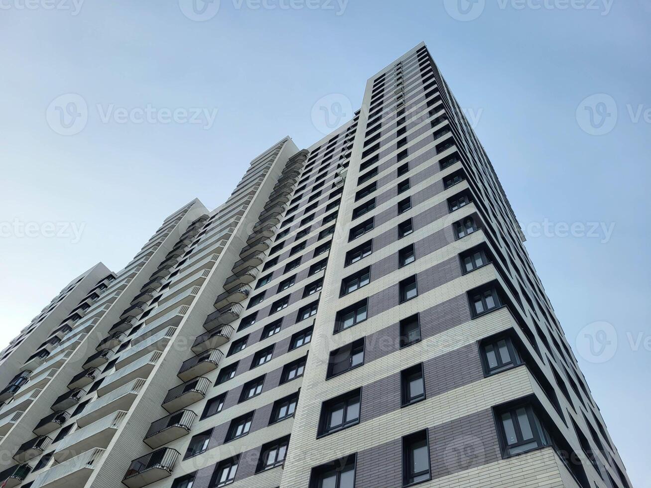 A fragment of the facade of a multi-storey building against a blue sky background photo