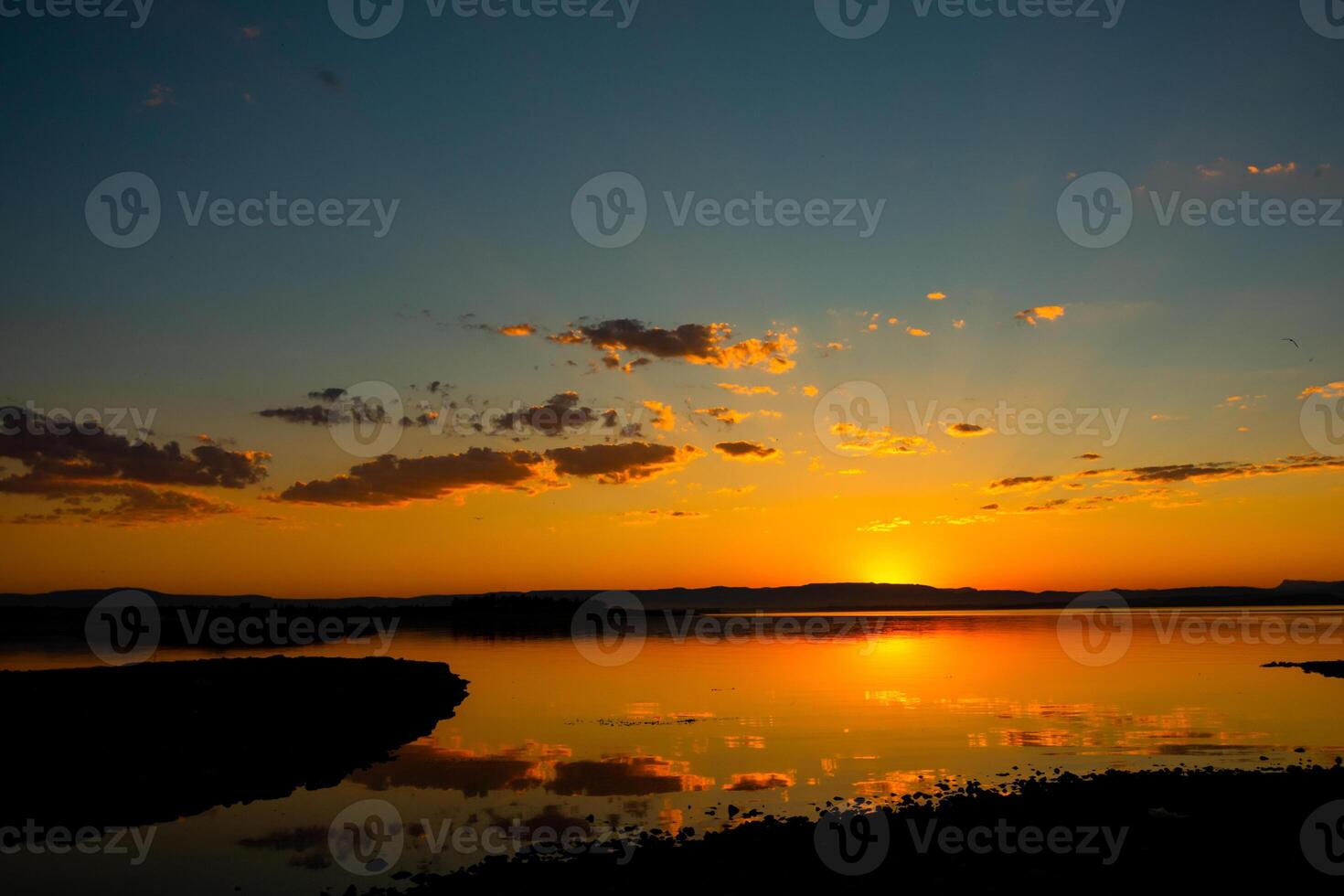 puesta de sol antecedentes foto. rayos de sol y parcialmente nublado cielo terminado el lago foto