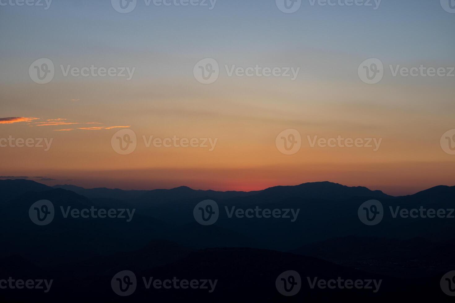 Silhouette of the hills at sunset with hazy sky. photo