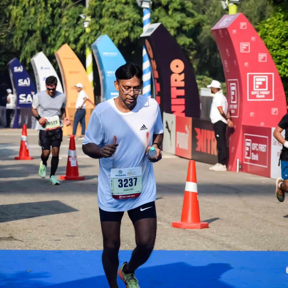 New Delhi, India - October 15 2023 - Vedanta Delhi Half Marathon race after covid in which marathon participants about to cross the finish line, Delhi Half Marathon 2023 photo