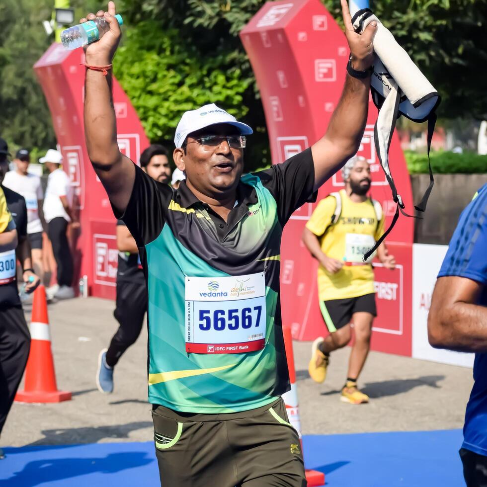 New Delhi, India - October 15 2023 - Vedanta Delhi Half Marathon race after covid in which marathon participants about to cross the finish line, Delhi Half Marathon 2023 photo