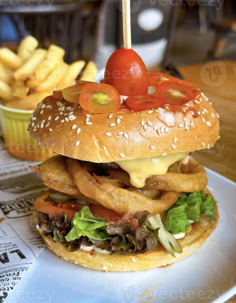 A tantalizing gourmet sandwich with fresh veggies and creamy sauce, served with crispy fries and a side of juice photo