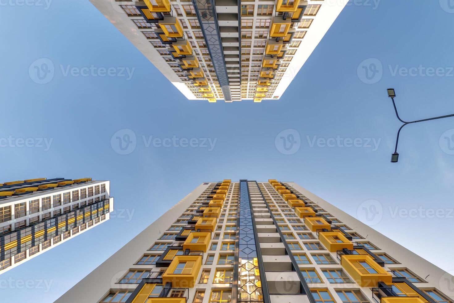 view from below into blue sky with clouds of large modern skyscraper residential complex photo