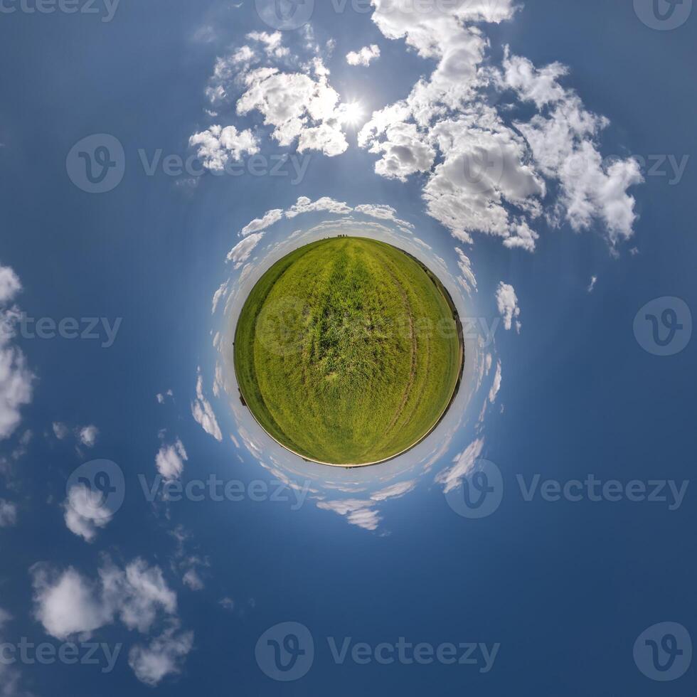 simple tiny planet without buildings in blue sky with beautiful clouds. Transformation of spherical panorama 360 degrees. Spherical abstract aerial view. Curvature of space. photo