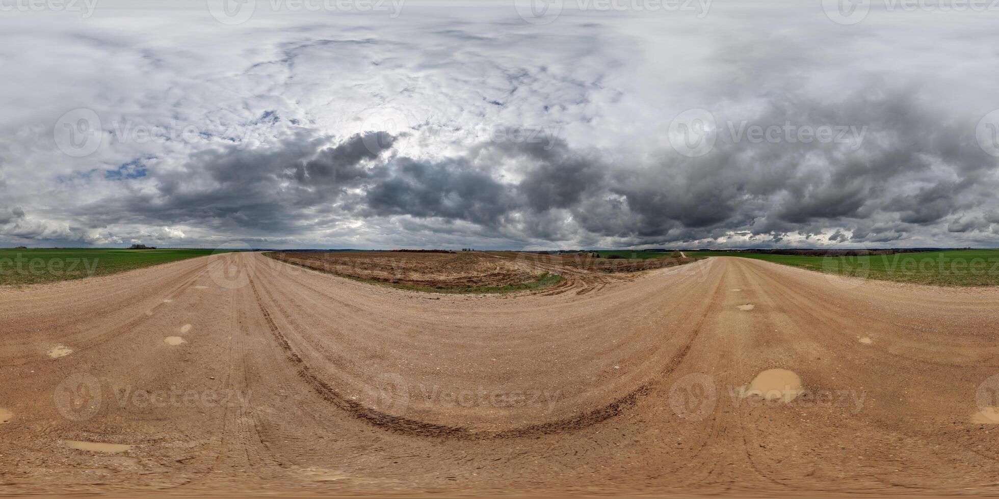 hdri 360 panorama on wet gravel road among fields in spring nasty day with storm clouds in equirectangular full seamless spherical projection, for VR AR virtual reality content photo