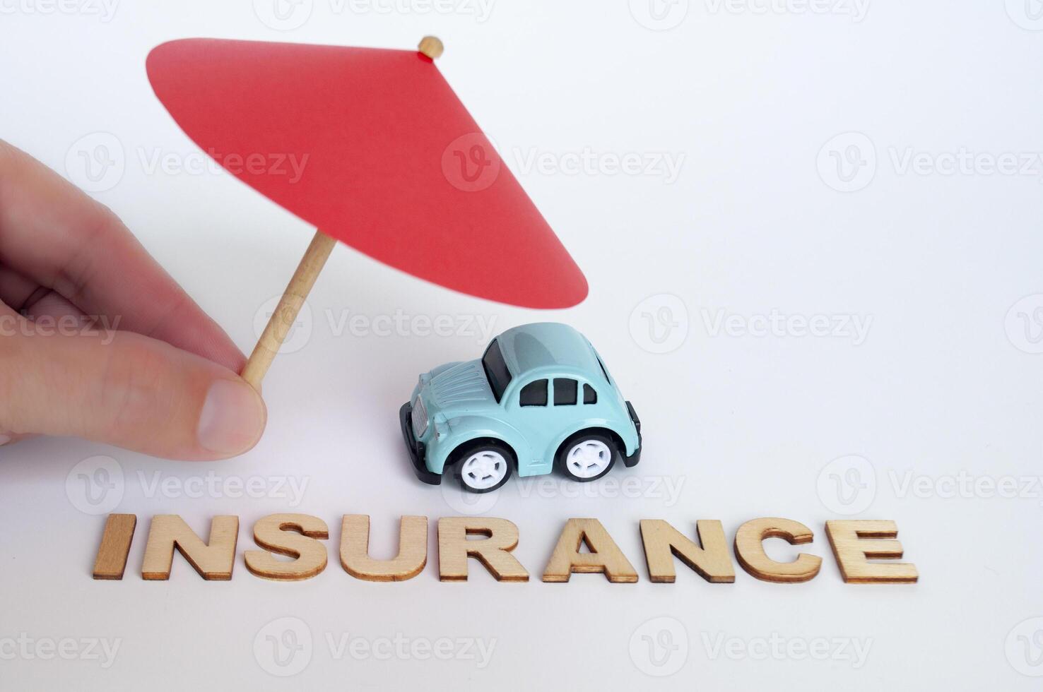 Insurance text with toy car and umbrella background. Car insurance concept photo