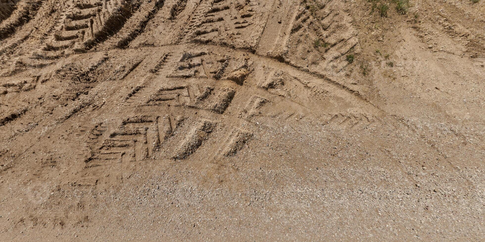 view from above on texture of wet muddy road with puddle and tractor tire tracks in countryside photo