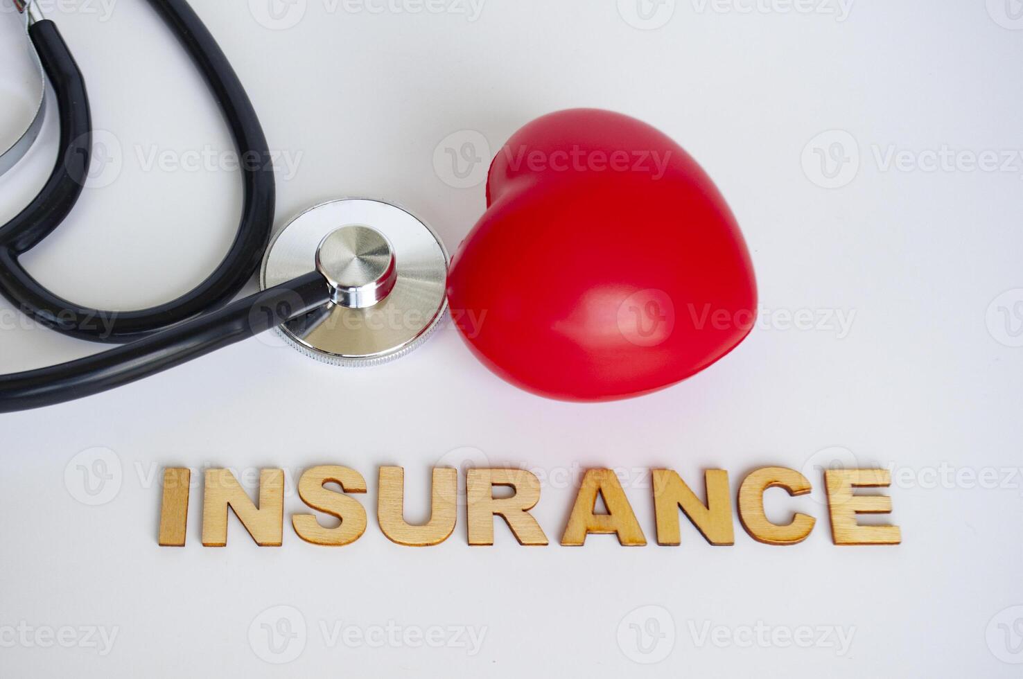 Heart shapes and stethoscope with insurance text on white background. Life insurance concept. photo