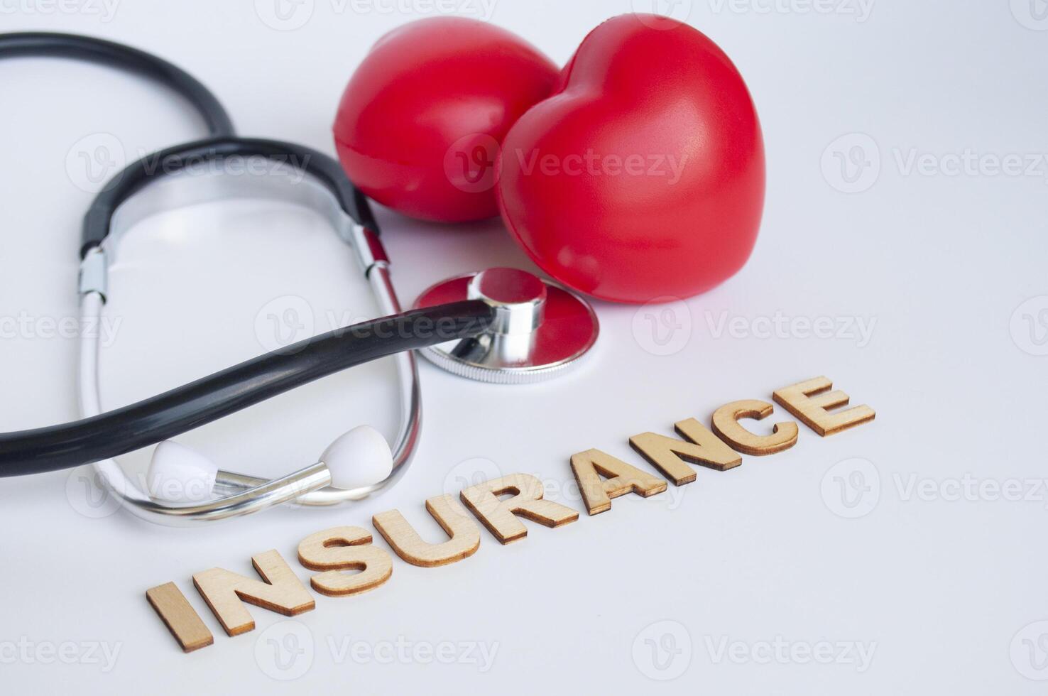 Side view of heart shapes and stethoscope with insurance text. Life insurance concept. photo