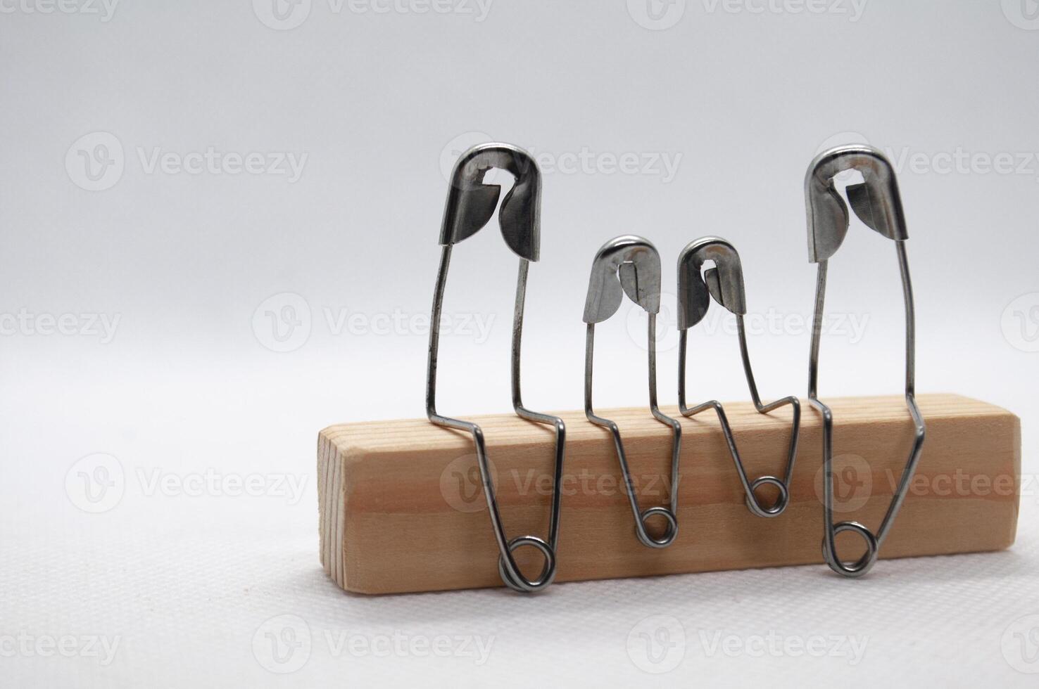 Model safety pin of family sitting on wooden block with customizable space for text photo