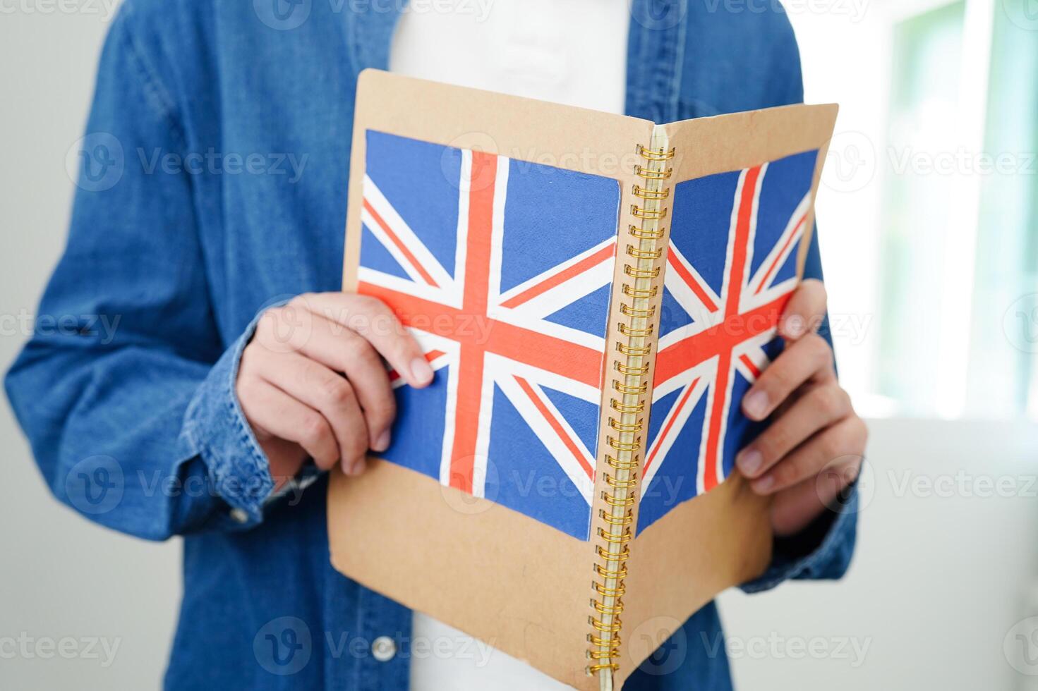 Learning English, Asian teenage student holding book with flag for language program education. photo