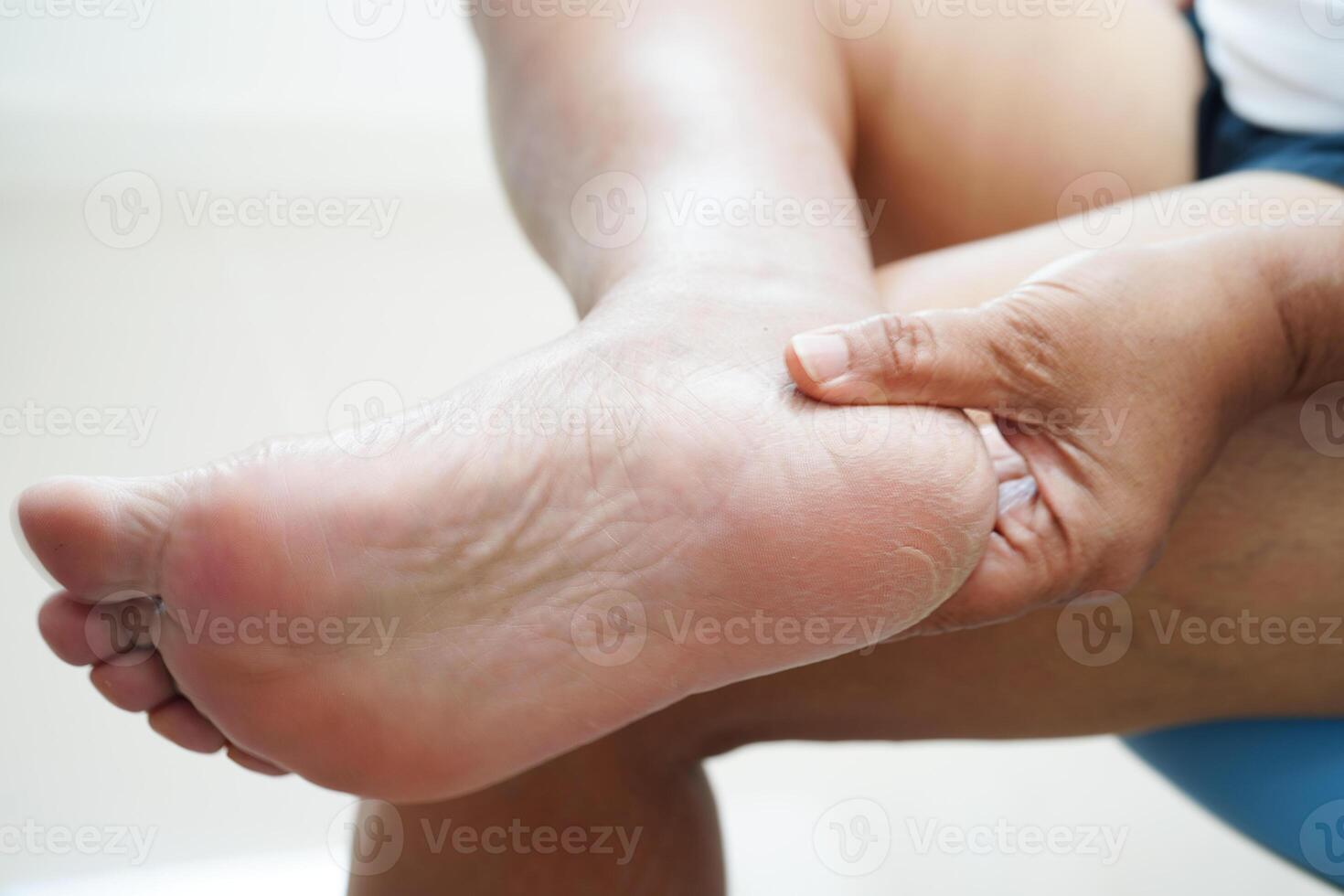 Asian woman applying moisturizing cream skincare treatment to solve and repair feet with crack and dry heel skin. photo
