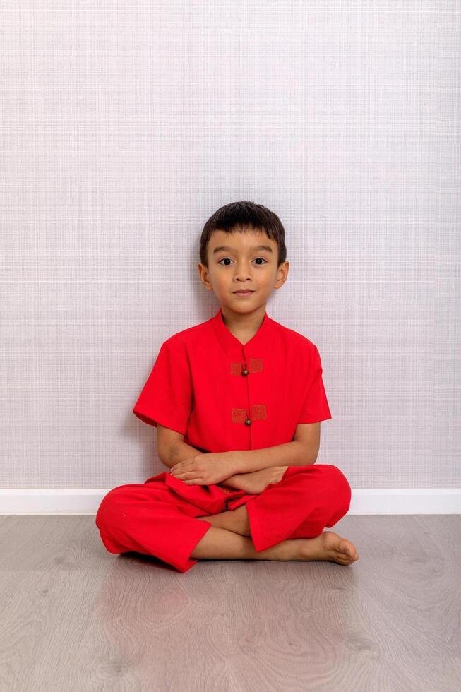 pequeño chico niño en rojo chino vestido, estilo y Moda ideas para niños. chino nuevo año foto