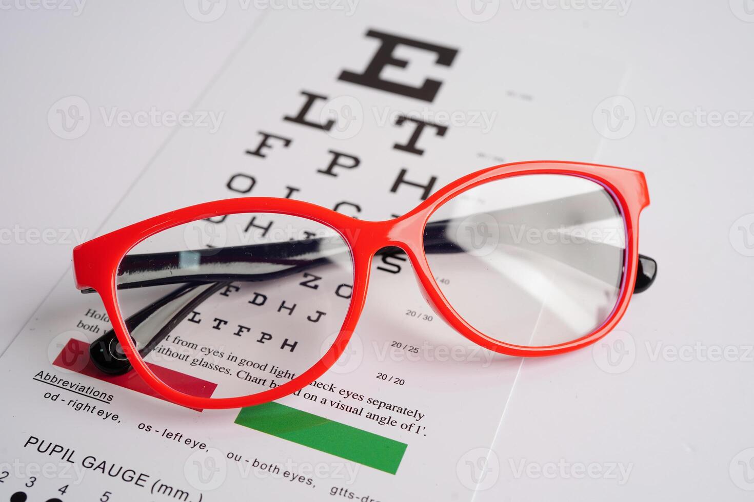 Glasses on eye exam chart to test eyesight accuracy of reading. photo