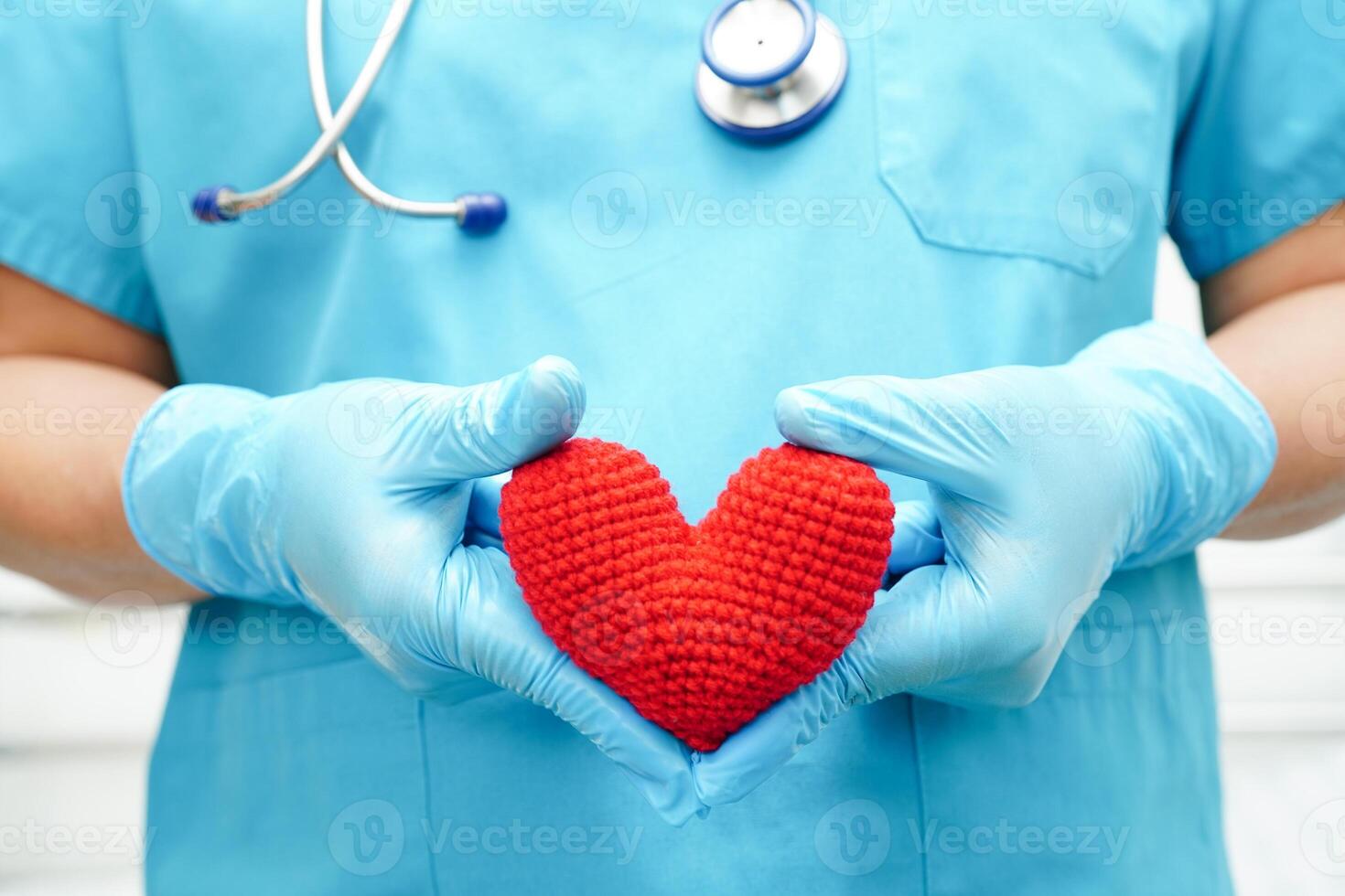 Asian woman doctor holding red heart for health in hospital. photo