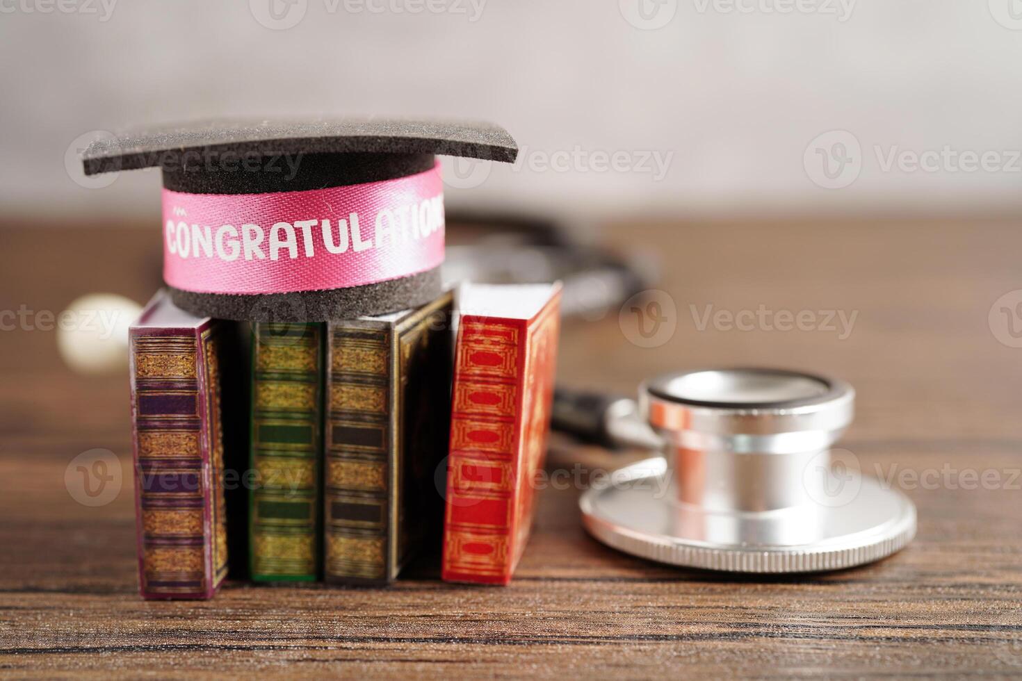 Graduation hat on book and stethoscope with copy space, doctor learning medicine university education concept. photo