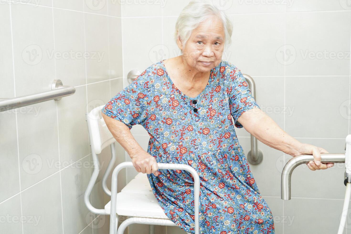 Asian elderly old woman patient use toilet support rail in bathroom, handrail safety grab bar, security in nursing hospital. photo