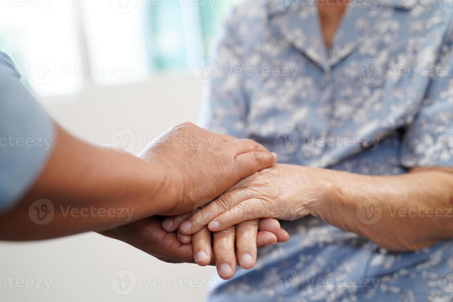 cuidador tomados de la mano paciente anciana asiática, ayuda y atención en el hospital. foto