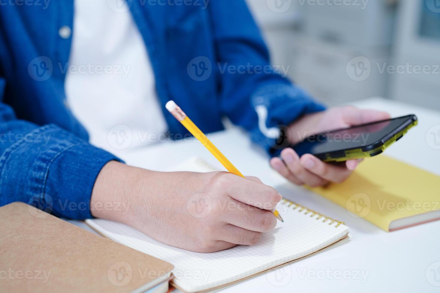 asiático Adolescente estudiante escribir tarea, estudiar lección para examen en línea aprendizaje educación. foto