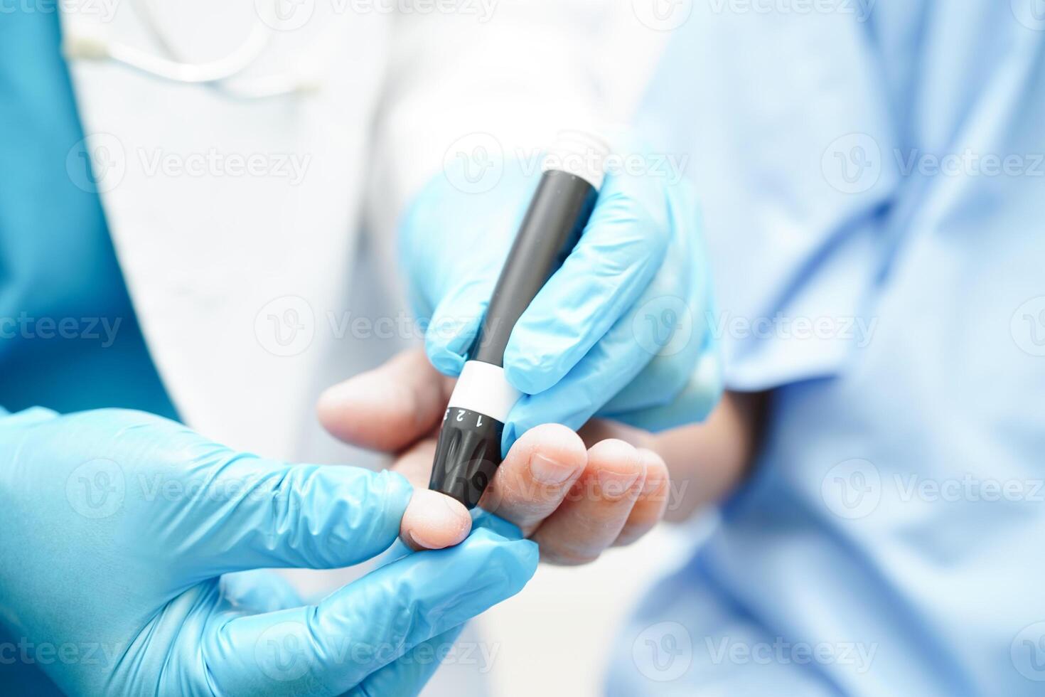 Asian doctor using lancet pen on senior patient finger for check sample blood sugar level to treatment diabetes. photo