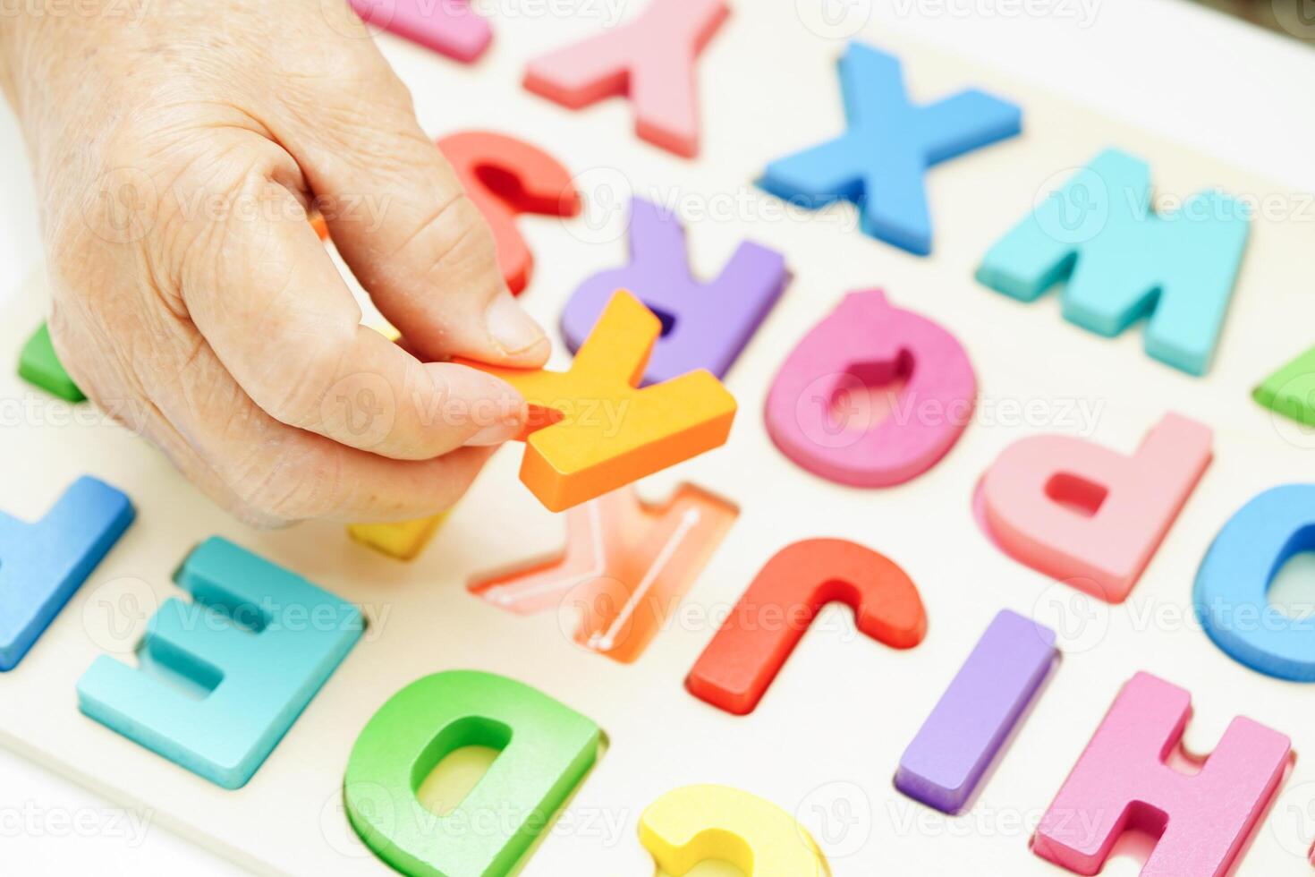 Asian elderly woman playing puzzles game for treatment dementia prevention and Alzheimer disease. photo