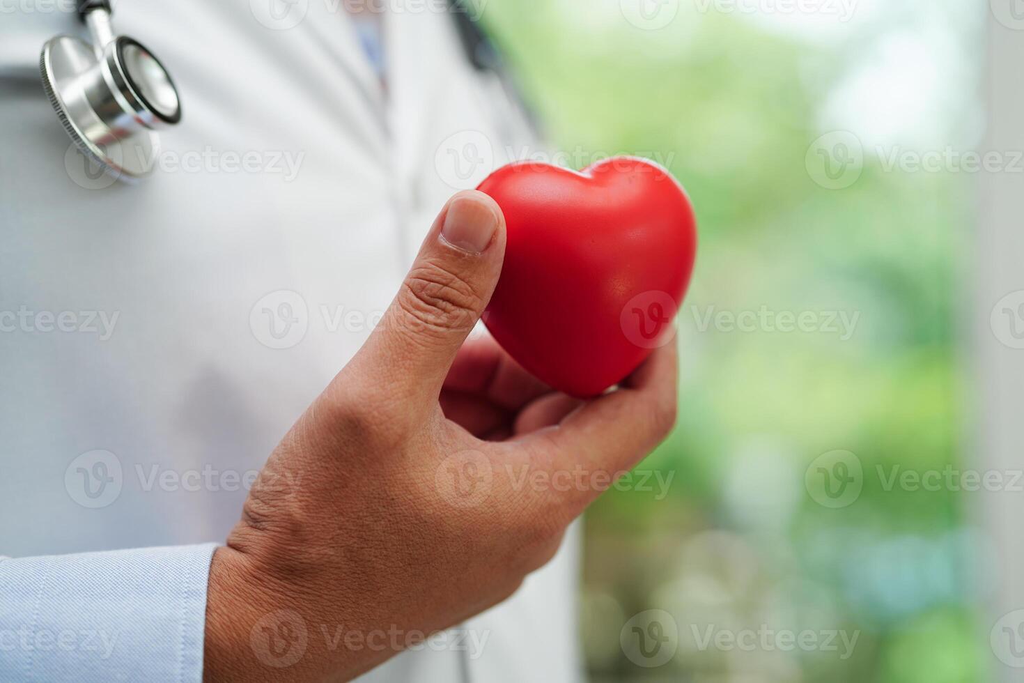 Asian woman doctor holding red heart for health in hospital. photo