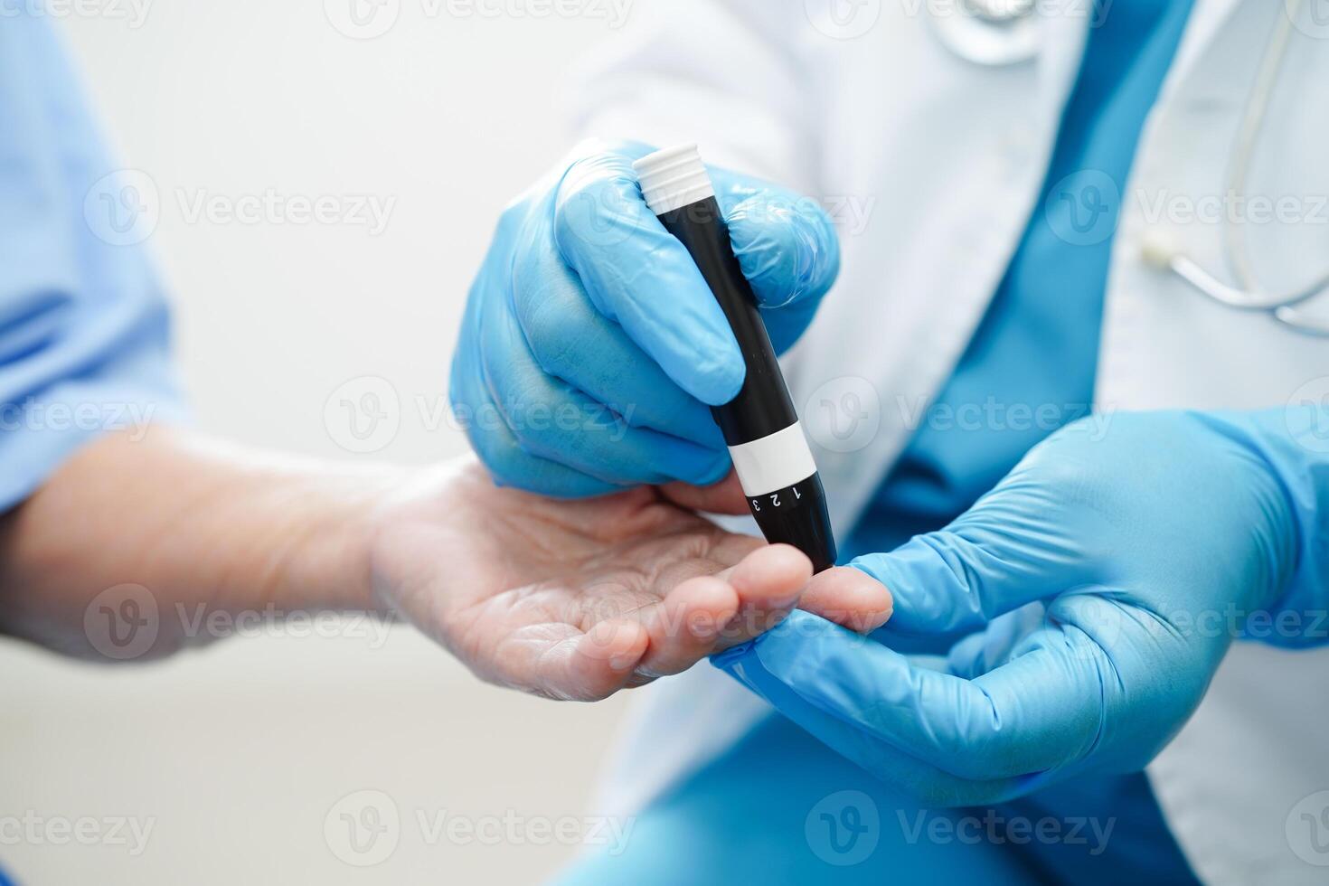 Asian doctor using lancet pen on senior patient finger for check sample blood sugar level to treatment diabetes. photo