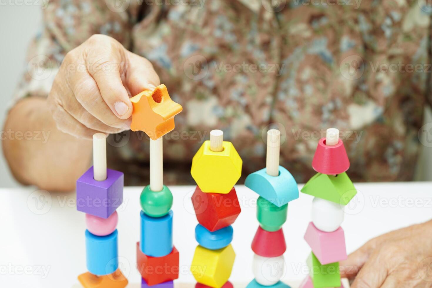 Asian elderly woman playing puzzles game for treatment dementia prevention and Alzheimer disease. photo