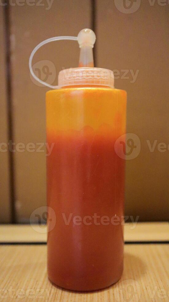 Vibrant Red Chilli Sauce in Clear Container for food topping. photo