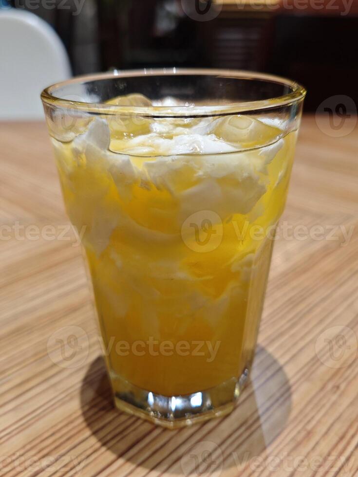Refreshing A Glass of Coconut and Orange Fusion Drink on Wooden Table photo