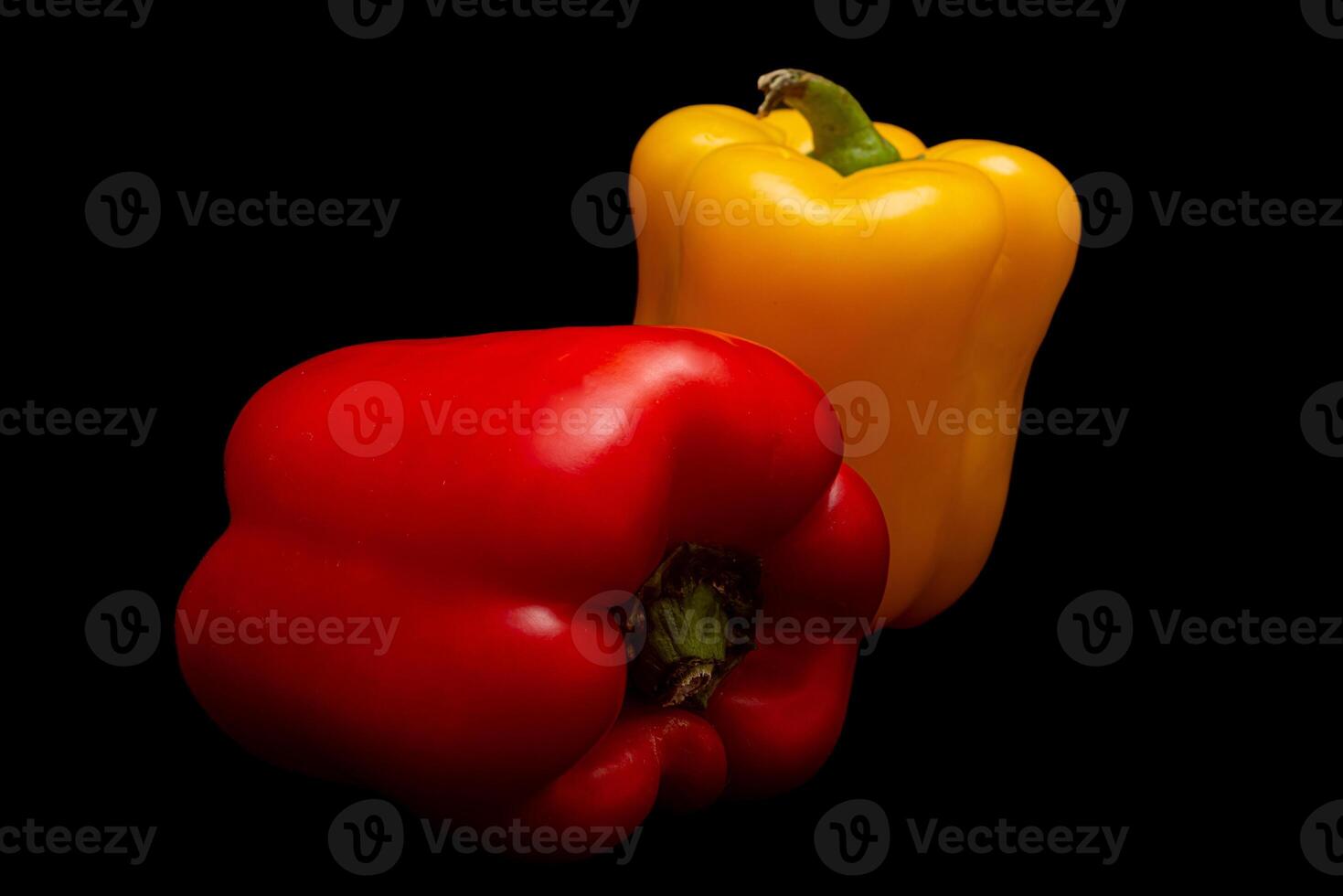 Red and yellow pepper in black background photo
