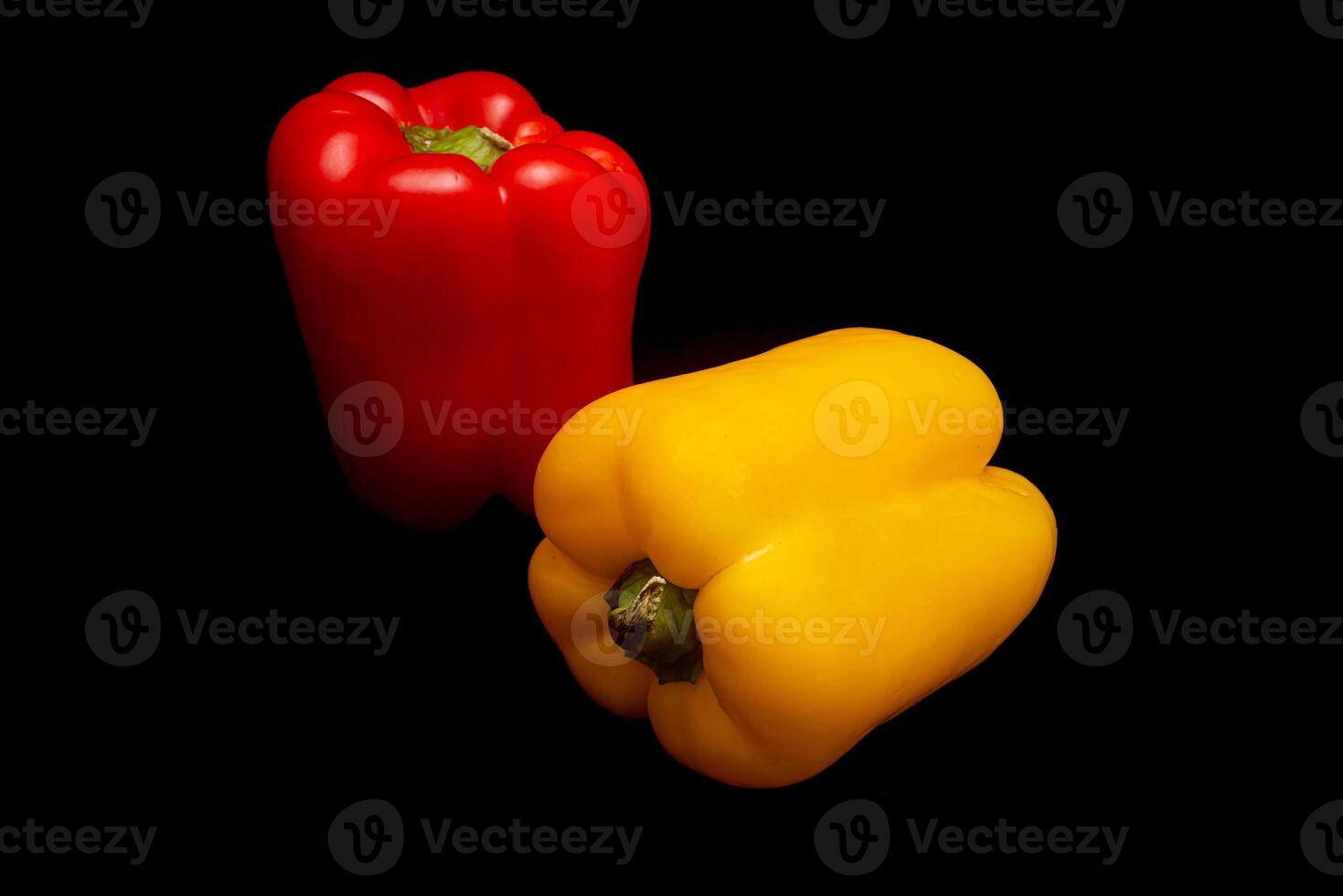 Red and yellow pepper in black background photo