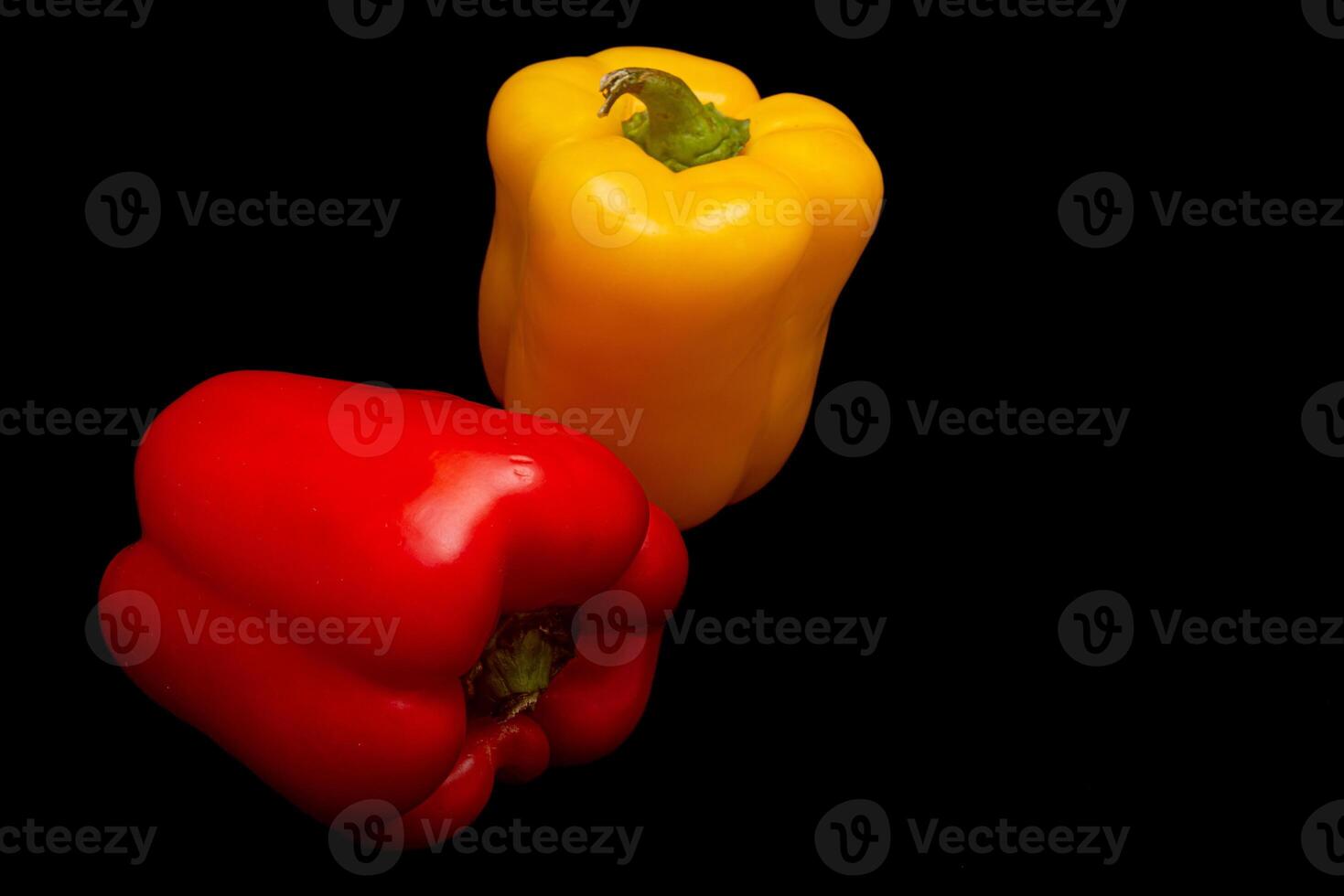 Red and yellow pepper in black background photo