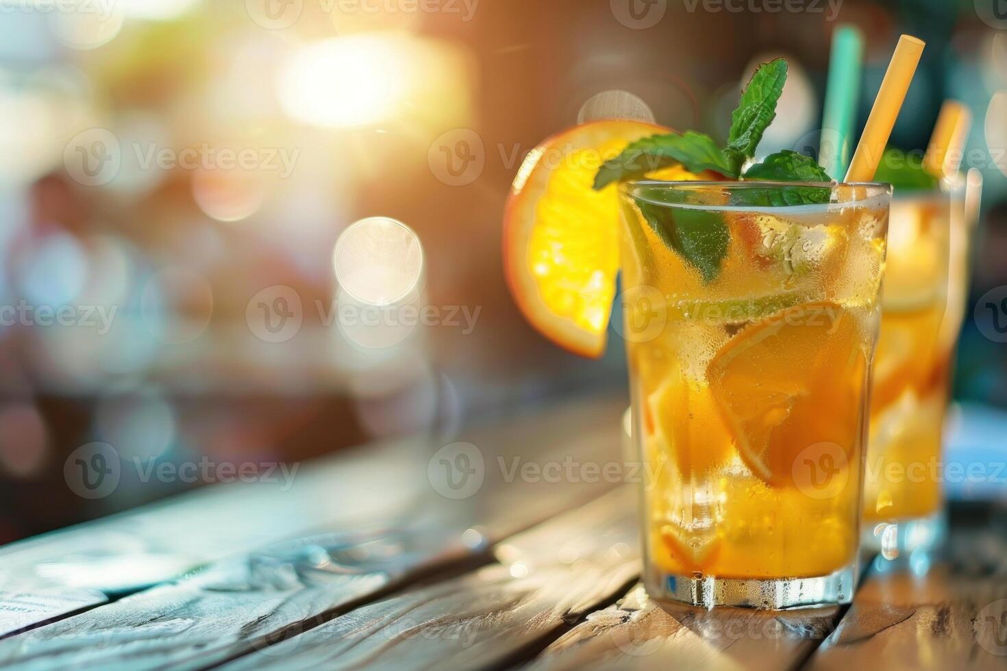 A glass of lemonade with a straw in it and a slice of lemon on the side photo