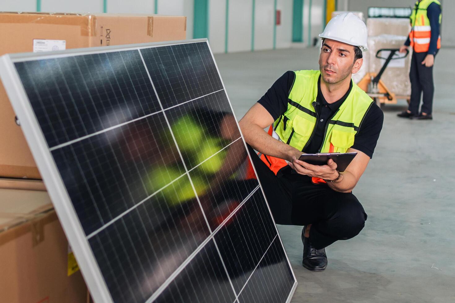 man in a yellow vest is looking at a solar panel photo