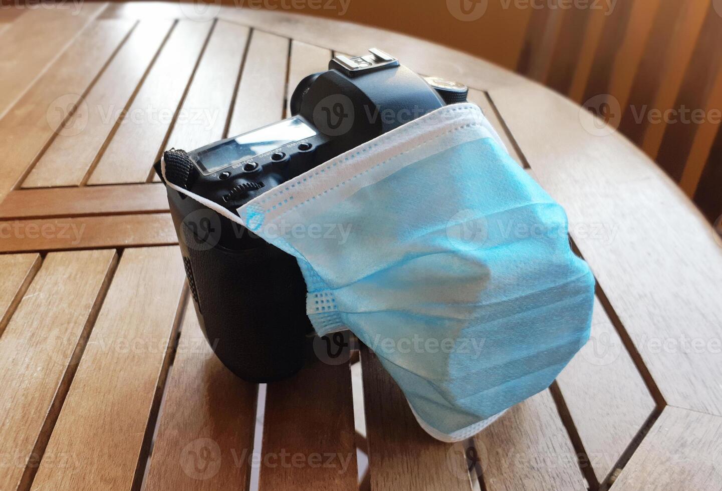 Surgical protective mask on reflex camera. Effect of the pandemic on the photographic sector. photo