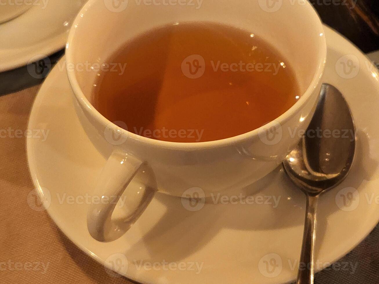 White cup with brewed tea. Fragrant tea in a white cup photo