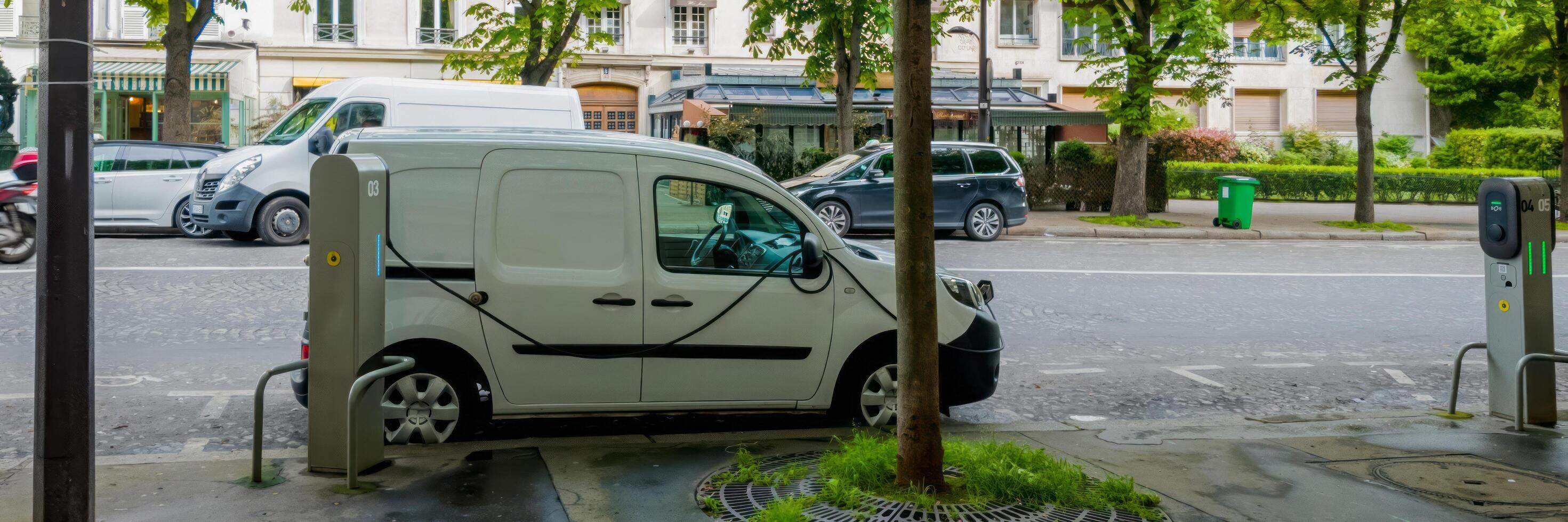 Electric vehicle plugged in at a charging station on an urban street, showcasing sustainable transportation and environmental consciousness photo