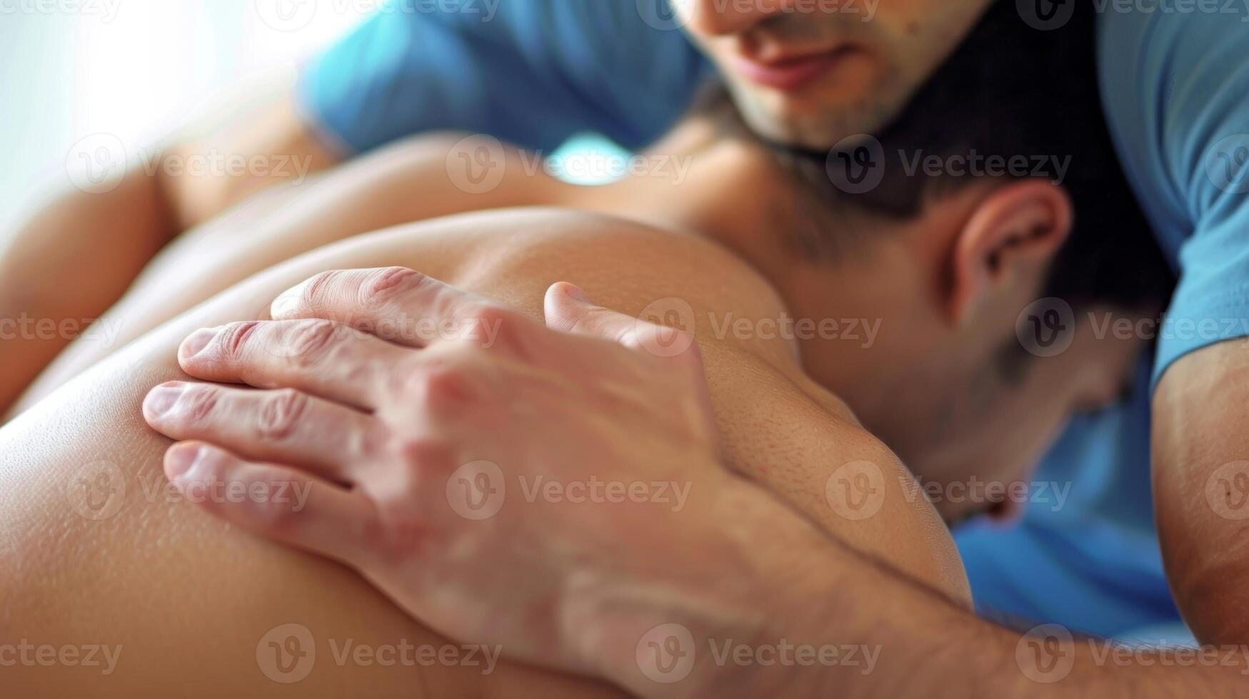 A view of a mans hands applying firm pressure onto a persons shoulders releasing tension and promoting deep tissue relaxation. photo