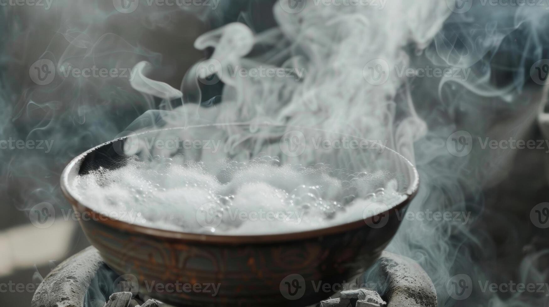 A closeup of steam rising from a bowl of water on hot coals creating a moist and soothing environment for easier breathing. photo