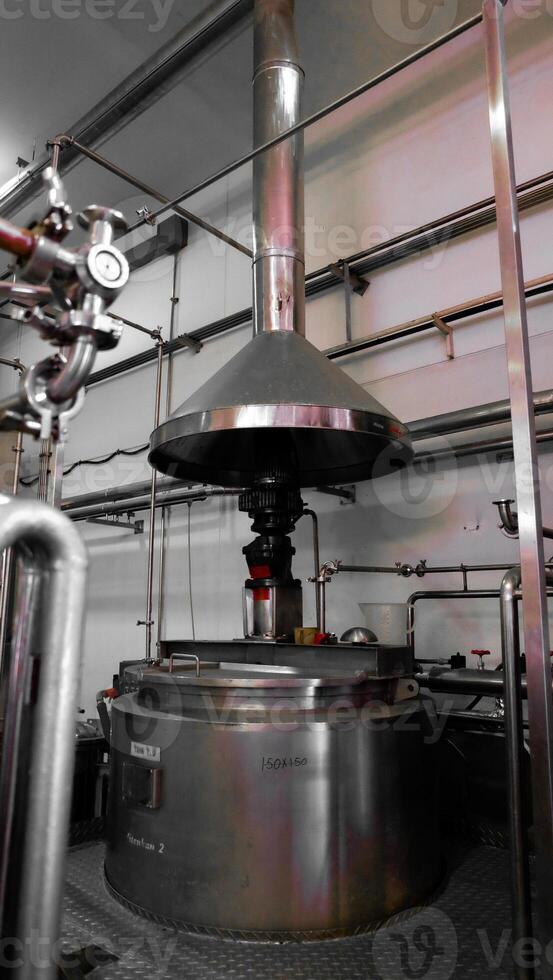 A large metal machine with pipes and valves, sitting on a metal platform. photo